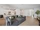 Spacious living room with a large couch, wood-look tile floors, and modern lighting at 5103 San Martino Dr, Wesley Chapel, FL 33543