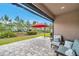 Paver patio features outdoor seating, a red umbrella, and views of a grassy lawn at 5103 San Martino Dr, Wesley Chapel, FL 33543