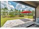 A relaxing patio area overlooking a lush green lawn and an umbrella for shade at 5103 San Martino Dr, Wesley Chapel, FL 33543