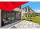 An outdoor patio with comfortable seating, a red umbrella, and views of the beautiful lawn at 5103 San Martino Dr, Wesley Chapel, FL 33543
