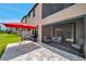 A covered patio with outdoor seating, a grill, a red umbrella, and views of the green lawn at 5103 San Martino Dr, Wesley Chapel, FL 33543