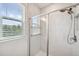 Contemporary shower showcasing a glass door, rainfall showerhead, and light tile at 5103 San Martino Dr, Wesley Chapel, FL 33543
