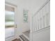 A bright staircase with white railings and grey wood steps leads to a glass door at 5103 San Martino Dr, Wesley Chapel, FL 33543