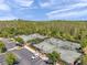Aerial view of community tennis courts with green surfaces, adjacent parking and surrounding trees, ideal for active living at 5103 San Martino Dr, Wesley Chapel, FL 33543
