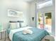 Bright bedroom featuring white walls, a large window, and a sliding door to a private outdoor space at 5111 28Th N Ave, St Petersburg, FL 33710