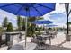 Outdoor kitchen and dining area with stainless steel grill, patio tables, and blue umbrellas, ideal for entertaining at 5120 125Th E Ave, Parrish, FL 34219