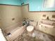 Dated bathroom featuring a tiled shower, toilet, and sink with yellow and blue paint at 6715 16Th N St, St Petersburg, FL 33702