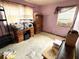 Bedroom with pink painted walls containing a desk, armoire, and window unit air conditioner at 6715 16Th N St, St Petersburg, FL 33702