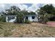 Modest one-story home with white exterior, blue trim, and mature landscaping at 6715 16Th N St, St Petersburg, FL 33702