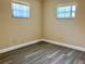 Cozy bedroom featuring new floors and two windows with blinds at 7425 W Maryland W Ave, Hudson, FL 34667