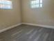 A bedroom with wood floor and two windows at 7425 W Maryland W Ave, Hudson, FL 34667