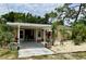 Charming single-story home with covered carport, decorative landscaping, and well-maintained front yard at 7425 W Maryland W Ave, Hudson, FL 34667