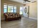 Cozy living room with wood-look floors, floral sofa, and a view of the front entrance at 7425 W Maryland W Ave, Hudson, FL 34667