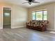 Spacious living room with wood-look floors, floral sofa, and view of the front yard at 7425 W Maryland W Ave, Hudson, FL 34667