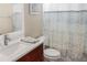 Neat bathroom featuring dark wood vanity, white sink, and a patterned shower curtain at 7533 Dunbridge Dr, Odessa, FL 33556