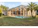 Backyard showcasing a screened-in pool with patio area and landscaped yard at 7533 Dunbridge Dr, Odessa, FL 33556