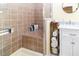 Tiled walk-in shower and vanity with a white cabinet in this remodeled bathroom at 7714 Sailwinds Pass, Port Richey, FL 34668