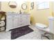 Bright bathroom with a double vanity, hexagon tile floor, and a toilet at 7714 Sailwinds Pass, Port Richey, FL 34668