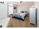 Bright bedroom featuring a queen bed, side table, dresser and a large window for natural lighting at 7714 Sailwinds Pass, Port Richey, FL 34668