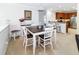 Bright dining area with white chairs, dark wood table, and adjacent kitchen at 7714 Sailwinds Pass, Port Richey, FL 34668