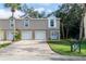 Charming townhome with a brick driveway, well-manicured lawn, and neutral-colored siding at 7714 Sailwinds Pass, Port Richey, FL 34668