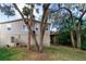 Exterior side view of home featuring second story deck and natural landscaping at 7714 Sailwinds Pass, Port Richey, FL 34668