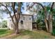 Side exterior view of home featuring a deck and lots of trees, plants and other natural landscaping at 7714 Sailwinds Pass, Port Richey, FL 34668