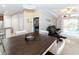 Open-concept dining and living area with a dark wood table and leather sofa at 7714 Sailwinds Pass, Port Richey, FL 34668