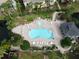 Aerial view of community pool featuring plenty of lounge chairs and a cabana for residents' enjoyment at 7714 Sailwinds Pass, Port Richey, FL 34668