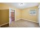 Bedroom features wood-look floors, natural light, and door leading to hall and other rooms at 7715 Deleuil Ave, Tampa, FL 33610