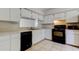 Functional kitchen featuring white cabinets, a double sink, and black appliances with tile floors at 8110 Pond Shadow Ln, Tampa, FL 33635