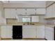 Kitchen with white cabinets, a double sink, black appliances, and neutral-colored tile flooring at 8110 Pond Shadow Ln, Tampa, FL 33635