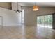 Large living room with tile floors, high ceilings, modern light fixture, and sliding glass doors at 8110 Pond Shadow Ln, Tampa, FL 33635