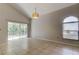 Spacious living room features tile flooring, large windows, sliding glass door, and a modern light fixture at 8110 Pond Shadow Ln, Tampa, FL 33635