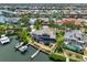 Aerial view of home with a boat dock and pools, offering scenic waterfront living with tropical views at 915 Symphony Isles Blvd, Apollo Beach, FL 33572
