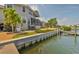Exterior shot of backyard with screened in porch, private dock, and canal at 915 Symphony Isles Blvd, Apollo Beach, FL 33572