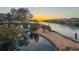 Relaxing backyard with a waterfront pool, stone patio, and picturesque sunset views at 915 Symphony Isles Blvd, Apollo Beach, FL 33572