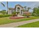 Stunning two-story home with mature landscaping, a lush lawn, and decorative flower beds at 915 Symphony Isles Blvd, Apollo Beach, FL 33572