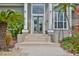 Inviting front entrance with an arched doorway, columns, and lush tropical plants at 915 Symphony Isles Blvd, Apollo Beach, FL 33572