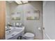 Neat half bathroom with a sink, mirror, artwork, and a toilet at 915 Symphony Isles Blvd, Apollo Beach, FL 33572