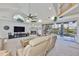 Spacious living room with fireplace, television, and sliding glass doors overlooking the canal at 915 Symphony Isles Blvd, Apollo Beach, FL 33572