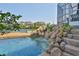 Beautiful pool with a rock waterfall feature and stunning waterfront views at 915 Symphony Isles Blvd, Apollo Beach, FL 33572