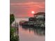 Sunset view of waterfront with private docks along calm waters, a serene place to moor your vessel at 915 Symphony Isles Blvd, Apollo Beach, FL 33572