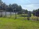 View of the chain link fenced in backyard with metal carport at 9722 Kenton Rd, Wesley Chapel, FL 33545