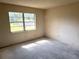 Empty bedroom with large window, offering ample natural light and a blank canvas for personalized design and decor at 9722 Kenton Rd, Wesley Chapel, FL 33545