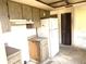 Outdated kitchen featuring wood cabinets, a white refrigerator, and essential appliances ready for a modern renovation at 9722 Kenton Rd, Wesley Chapel, FL 33545