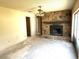 Living room with stone fireplace, ceiling fan, and sliding glass doors, presenting an opportunity for modernization at 9722 Kenton Rd, Wesley Chapel, FL 33545