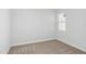 This bedroom features neutral carpet, white walls, and a bright window at 10017 Surrey Rose Dr, San Antonio, FL 33576