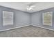 Spacious bedroom with gray walls, unique carpet, and two bright windows at 10435 Tassel St, Spring Hill, FL 34608