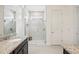 Bathroom featuring a marble walk-in shower, gray cabinetry, and double granite vanity at 10625 Cardera Dr, Riverview, FL 33578